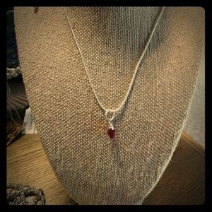 Silver necklace with red crystal charm